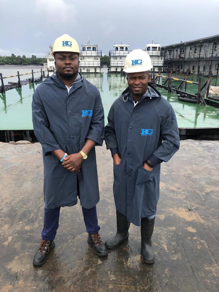 Two Kaizen Global staff in hard hats at a jetty